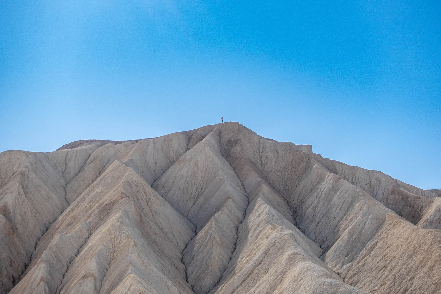A lone hiker on an unnamed summit near Zabriskie Point